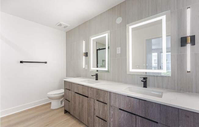 A bathroom with a toilet, sink, and mirror.