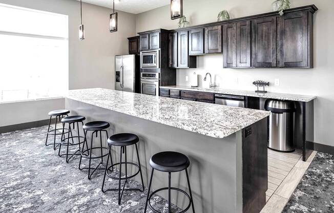 a kitchen with a long counter with bar stools