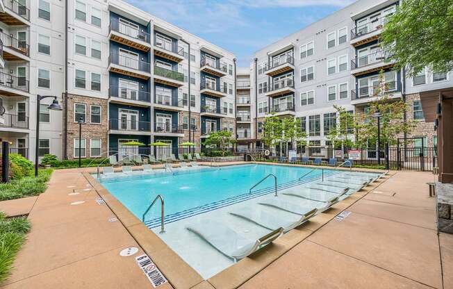 an apartment swimming pool in front of an apartment building