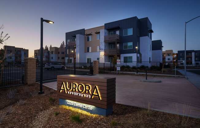 Aurora Apartments monument sign with community in the background