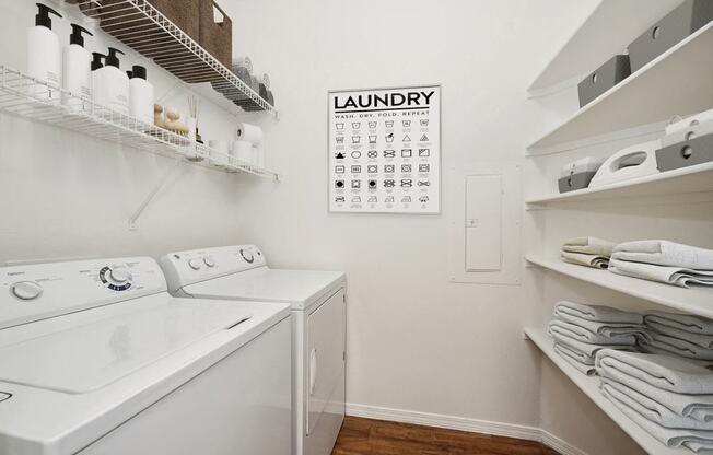 a laundry room with a washer and dryer and a calendar on the wall