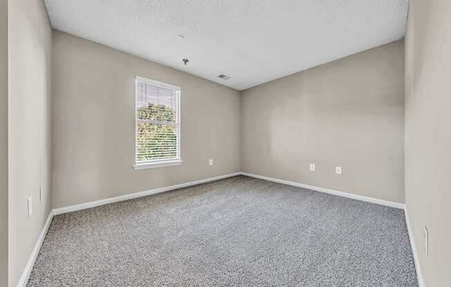 an empty room with carpet and a window