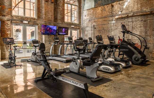 A gym with treadmills, stationary bikes, and a rowing machine.