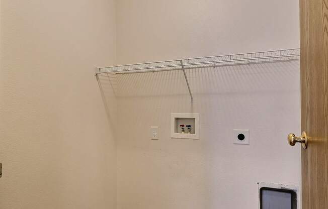 A closet with washer and dryer hookups in the corner. Fargo, ND Eagle Run Apartments.