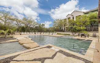 A large outdoor pool surrounded by stone steps.