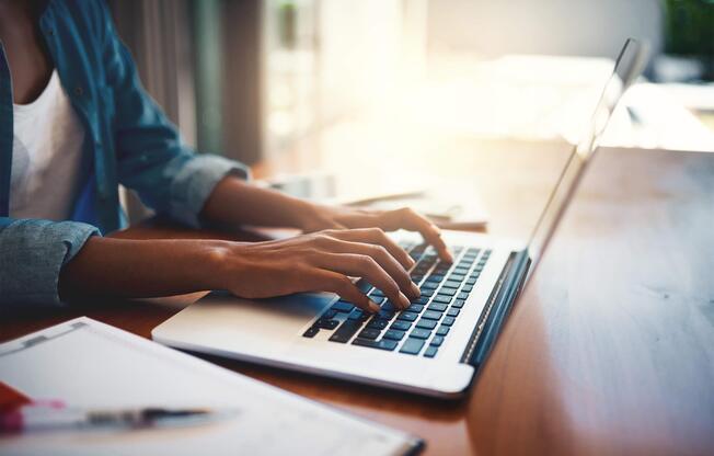 a person using a laptop computer sitting on top of a table