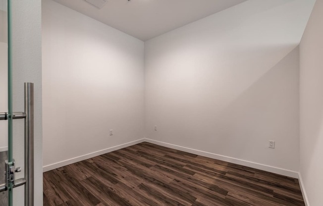 Spacious bedroom with hardwood floor in Live and Work apartment at 1400 FIG Apartments in Los Angeles, California.