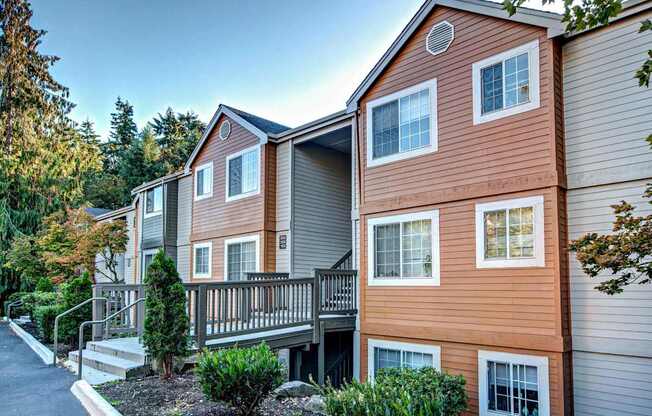 Apartment building with a balcony and a small garden in front.