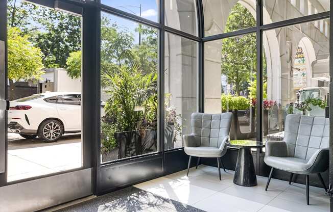 Two chairs are placed in front of a glass wall.