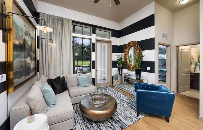 a living room with a gray couch and a blue chair