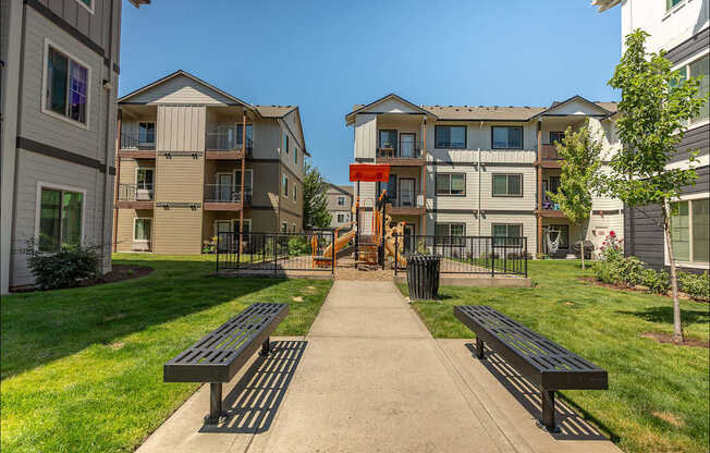 A sunny day at a residential area with apartment buildings and benches at Forestplace Apartment Homes, Oregon, 97116