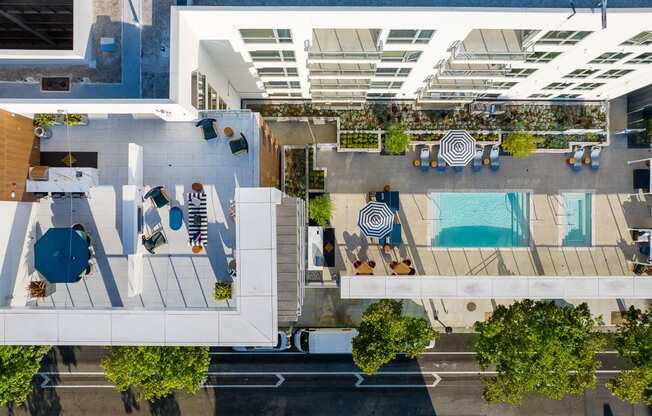 an overhead view of a building with a pool and trees
