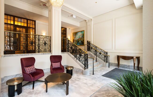 a lobby with chairs and a staircase  at The Belden Stratford, Chicago, IL