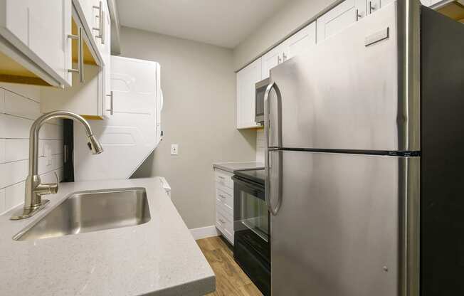 a kitchen with a stainless steel refrigerator and sink