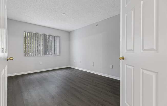 an empty living room with white walls and wood floors