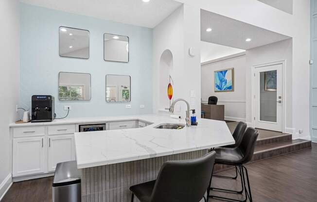 Clubhouse kitchen with a white countertop and a black chair.