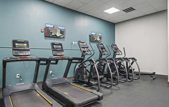 a room filled with cardio machines and a flat screen tv  at The Icon, Richmond, VA