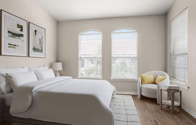 A bedroom with a large bed and a window with blinds.