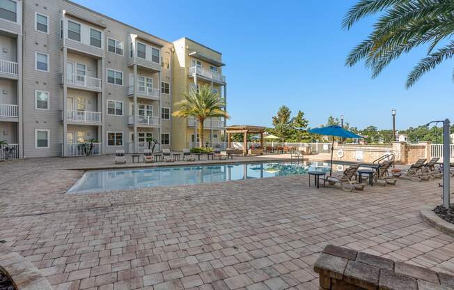 a swimming pool with an apartment building in the background