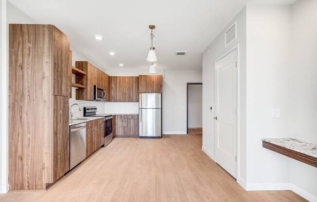 a kitchen with wooden cabinets and a stainless steel refrigerator