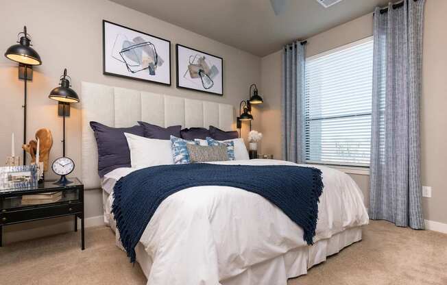 A bedroom with a white bed and blue blanket.