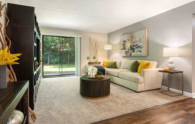 A living room with a white couch and a painting on the wall.