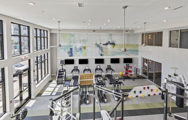 the lobby of a gym with chairs and a large wall of windows