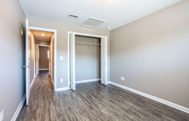 a empty room with a hallway and a closet