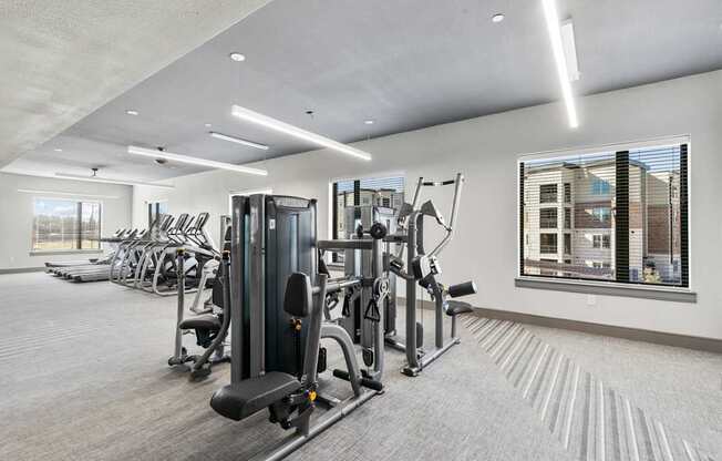 A well-lit gym with a variety of equipment.