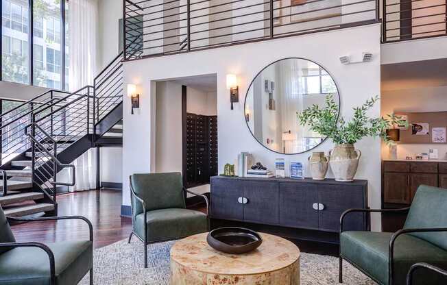 A living room with a staircase and a mirror on the wall.