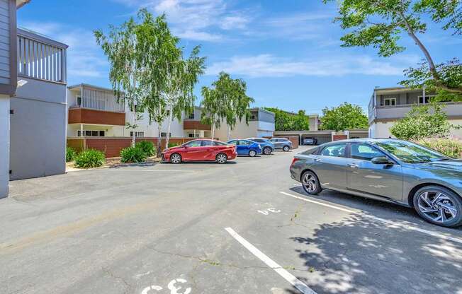 A parking lot with cars and a building in the background.