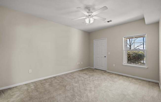 A room with a ceiling fan and a window.