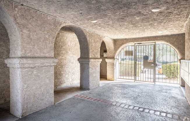 A room with arched columns and a tiled floor.