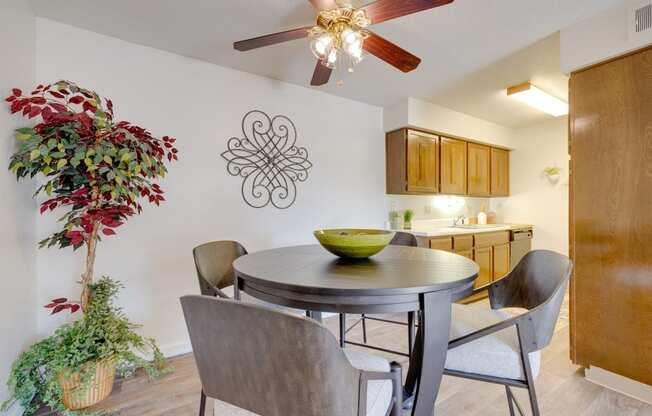 Dining area in the two-bedroom model unit at Olde English Village, with the kitchen visible in the background.