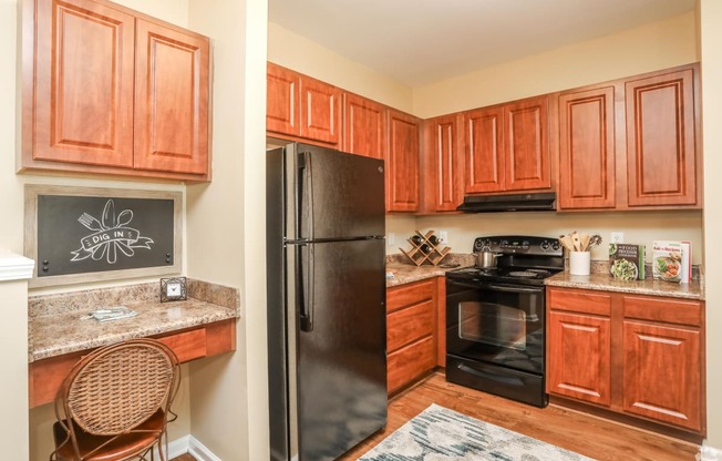 a kitchen with wood cabinets and black appliances and a black refrigerator