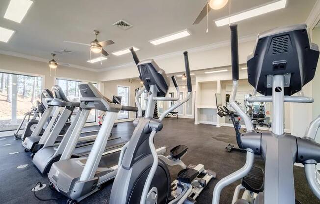 a gym with various cardio machines and weights