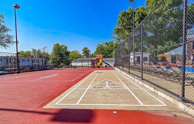 a tennis court with a fence and a red court