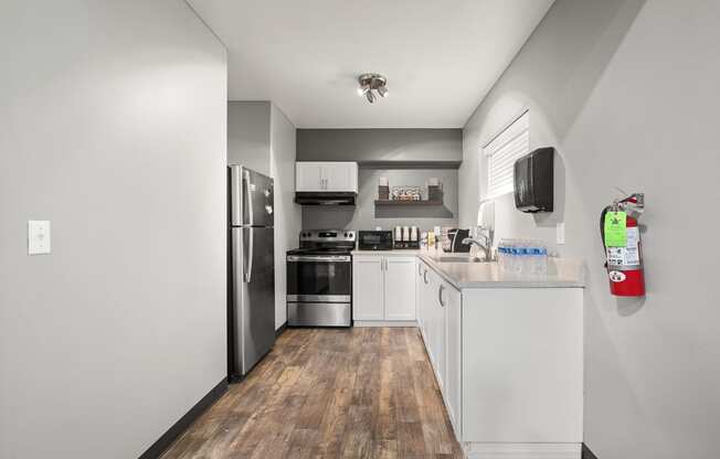 a kitchen with white cabinetry and stainless steel appliances at Mill Pond Apartments, Auburn, WA 98092