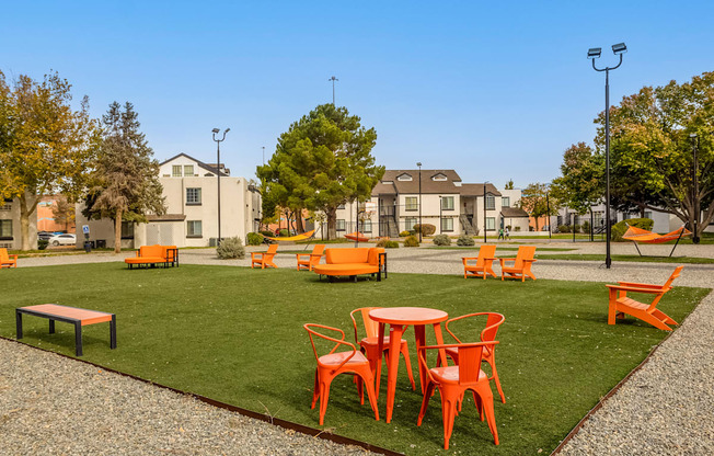 an outdoor seating area with tables and chairs on the grass