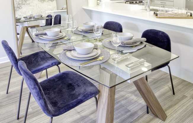 a contemporary dining room with a glass table and purple chairs at The Enclave, Jersey City, NJ, 07310