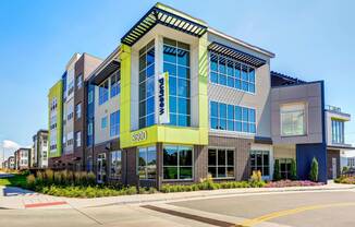 Exterior of Westend Apartments. Building features large windows and lime detailing on the front corner.