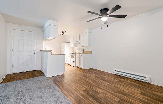 A room with a ceiling fan and a rug on the floor.