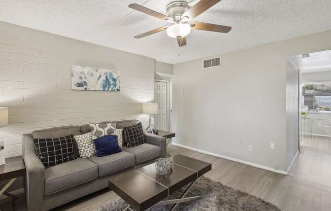 a living room with a couch and a ceiling fan