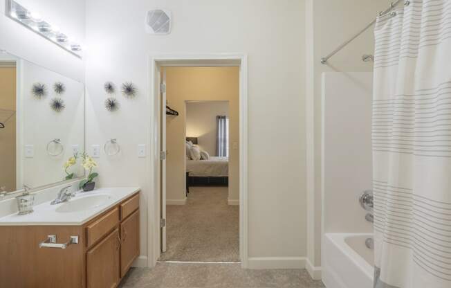 a bathroom with a shower and a sink and a mirror