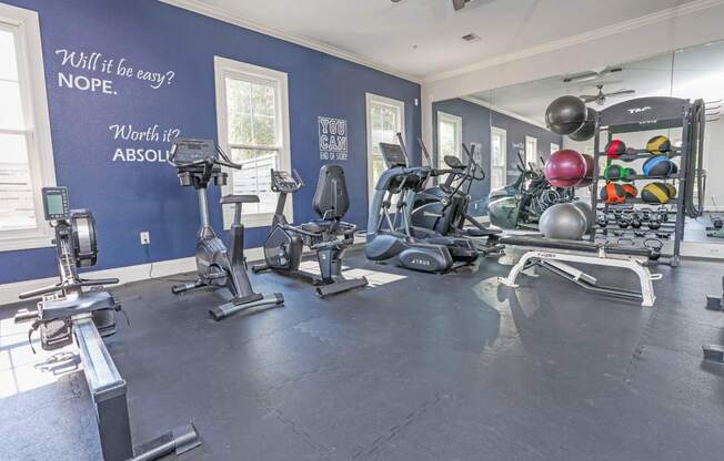 A gym with a variety of equipment and motivational quotes on the wall at Ultris Island Park in Shreveport, LA