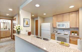 a kitchen with white appliances and wooden cabinets