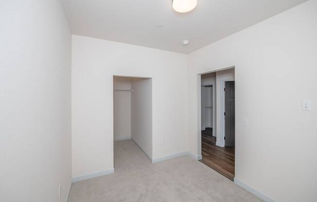 a living room with white walls and a door to a hallway at The Crossings at Windsong, Arizona