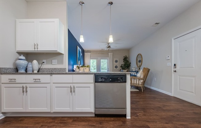 a kitchen with white cabinets and a stainless steel dishwasher