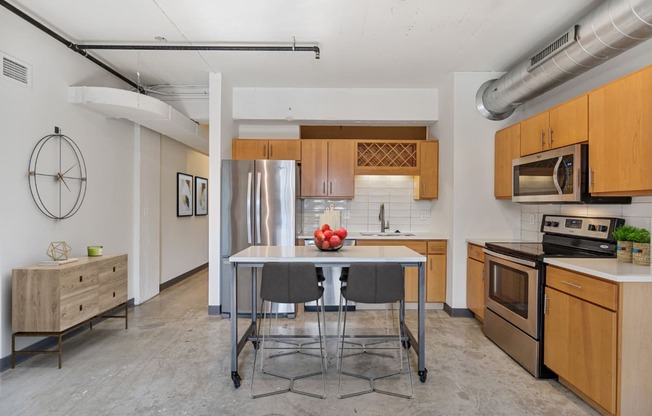 a kitchen with a stainless steel refrigerator and a table with chairs