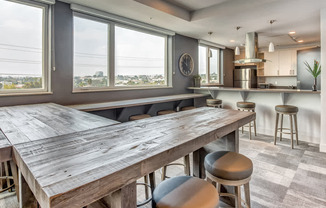 A kitchen with a large wooden table and bar stools.